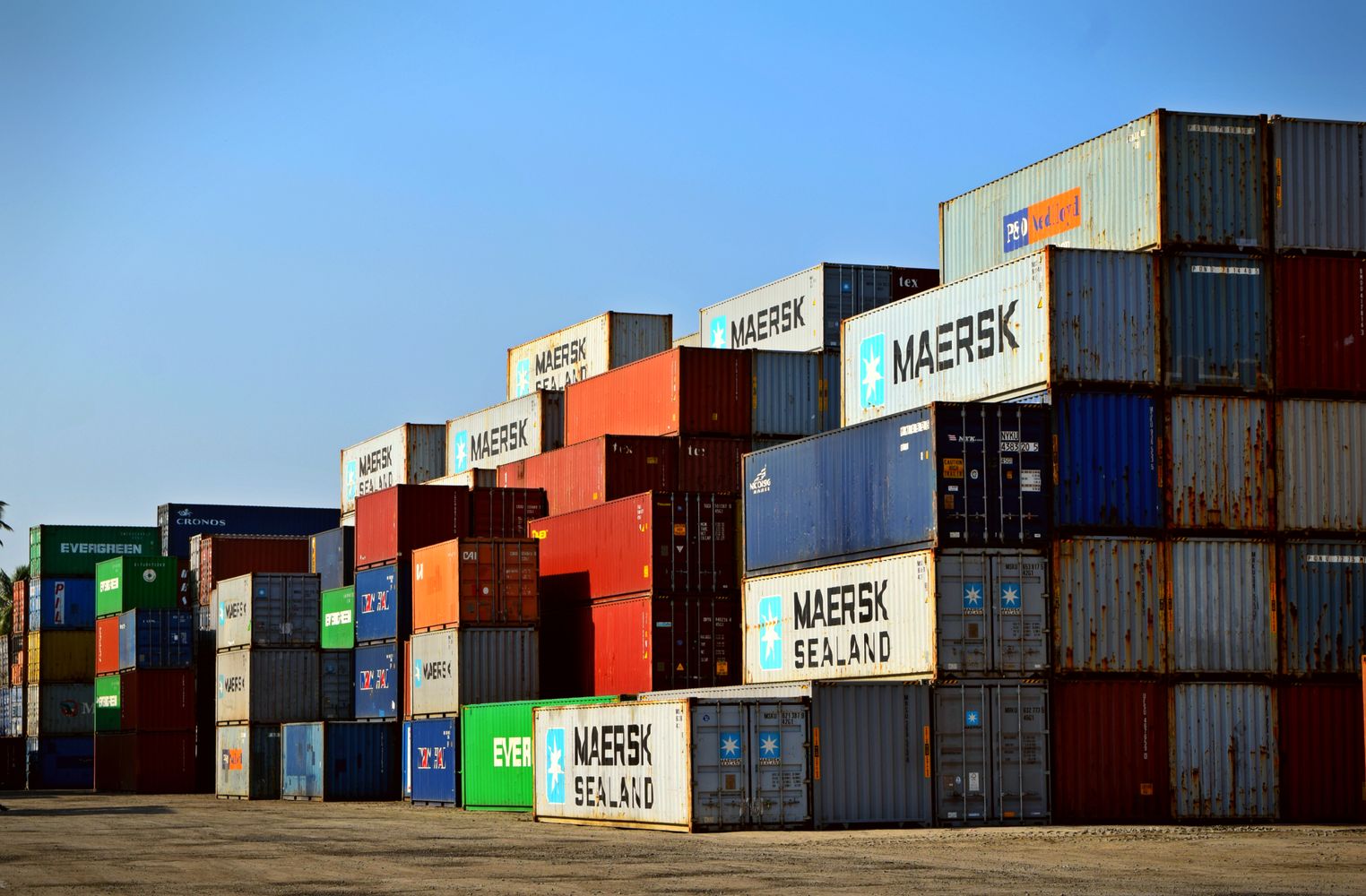 Stacked cargo containers at a port, representing export logistics and global delivery.