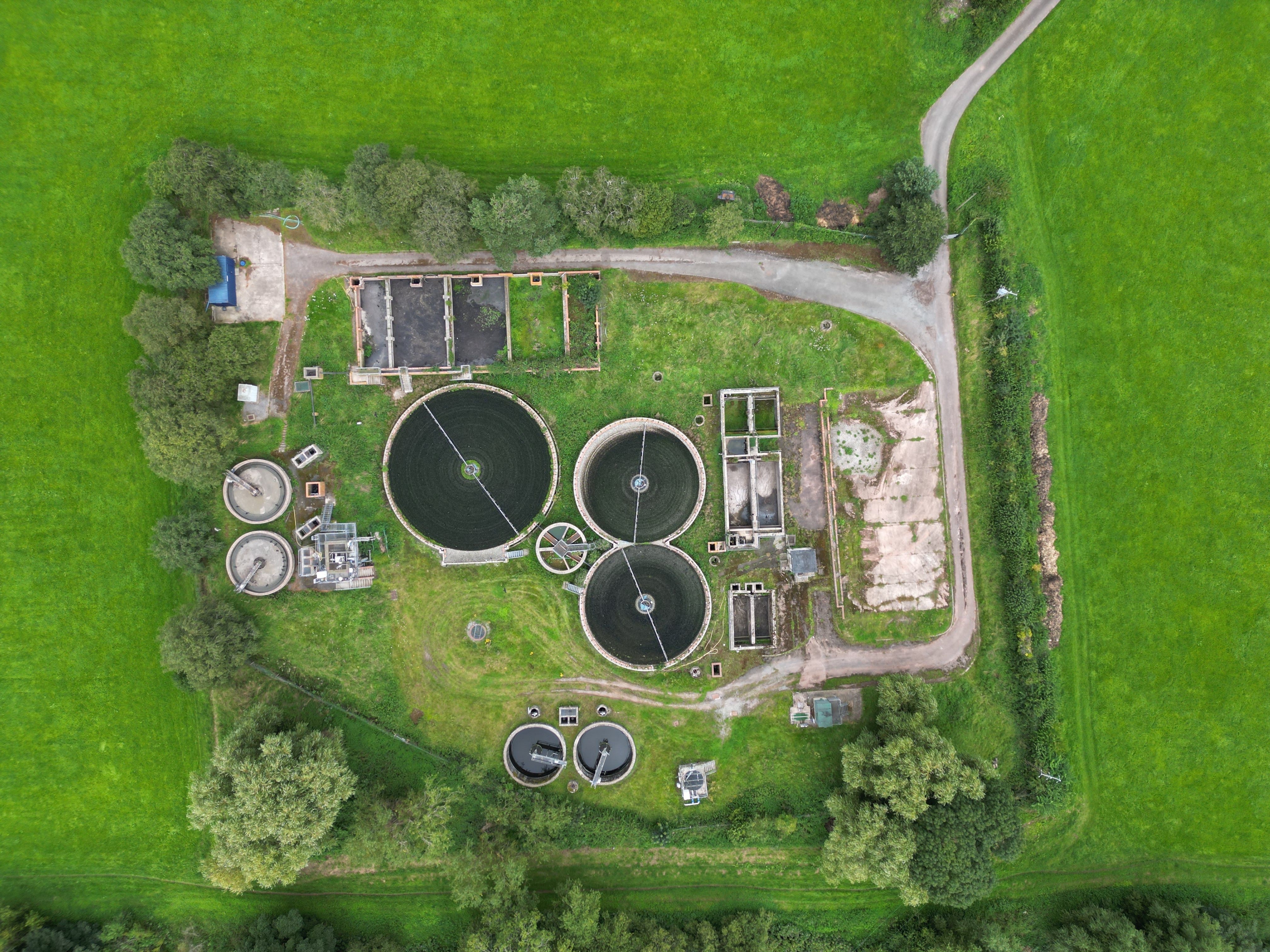 Aerial view of a wastewater treatment facility and its surrounding infrastructure.